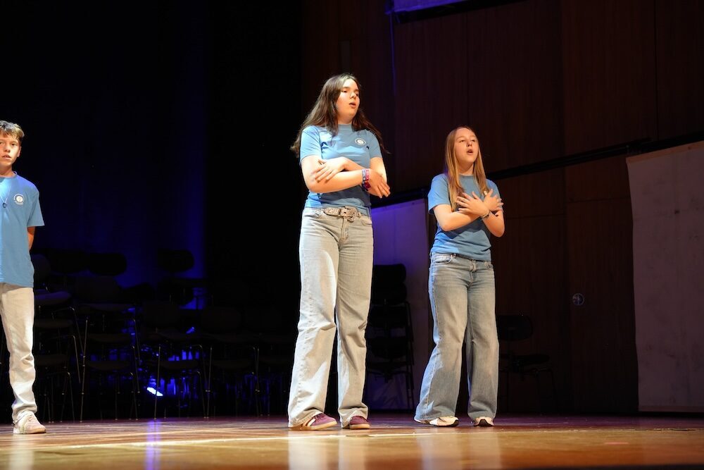 Zwei Schülerinnen singen in hellblauen T-Shirts, Best of Schulwerk 2026